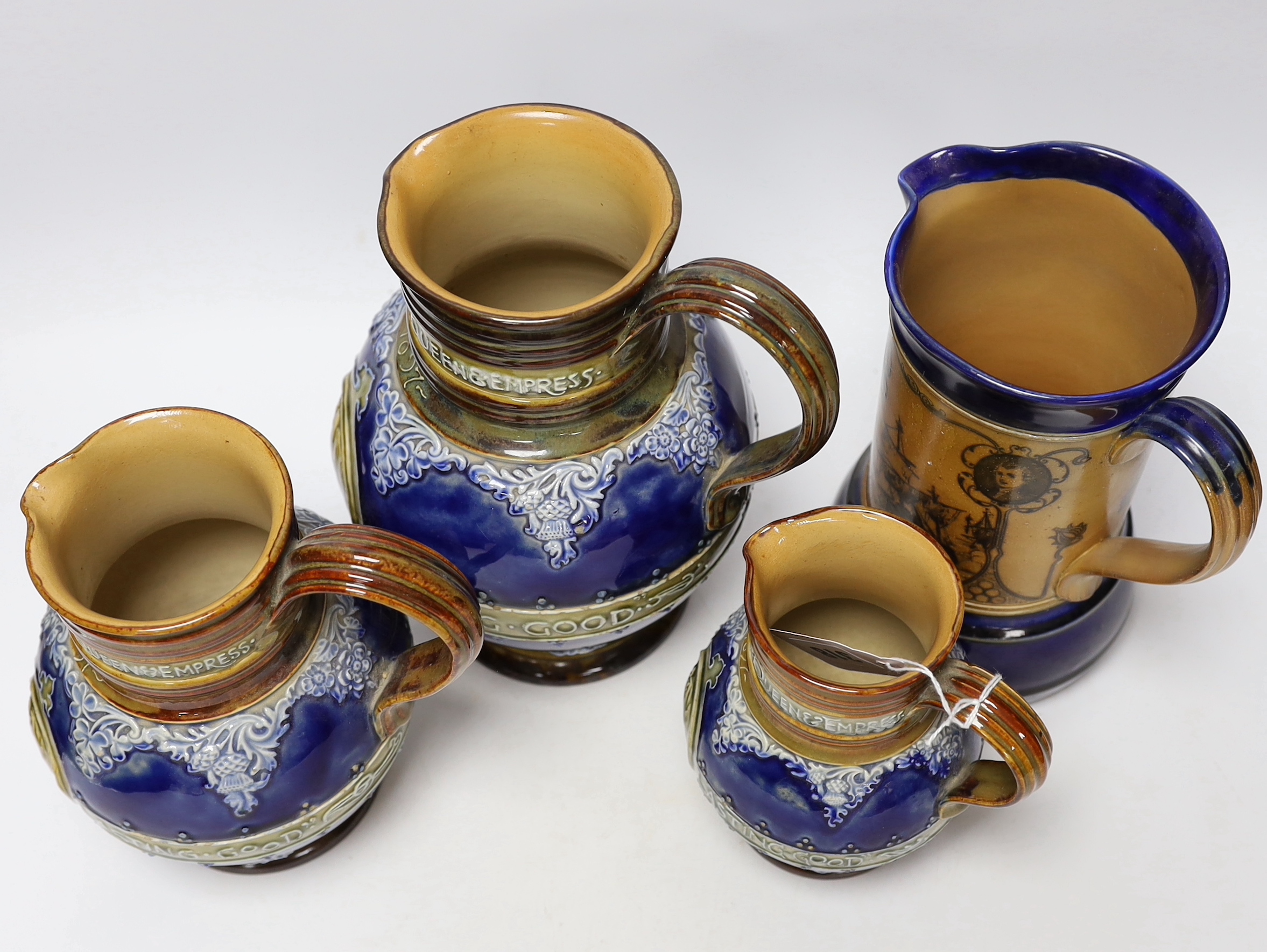 Three graduated Doulton Lambeth Queen Victoria diamond Jubilee commemorative jugs and a Nelson and his captains commemorative jug, largest 21cm high